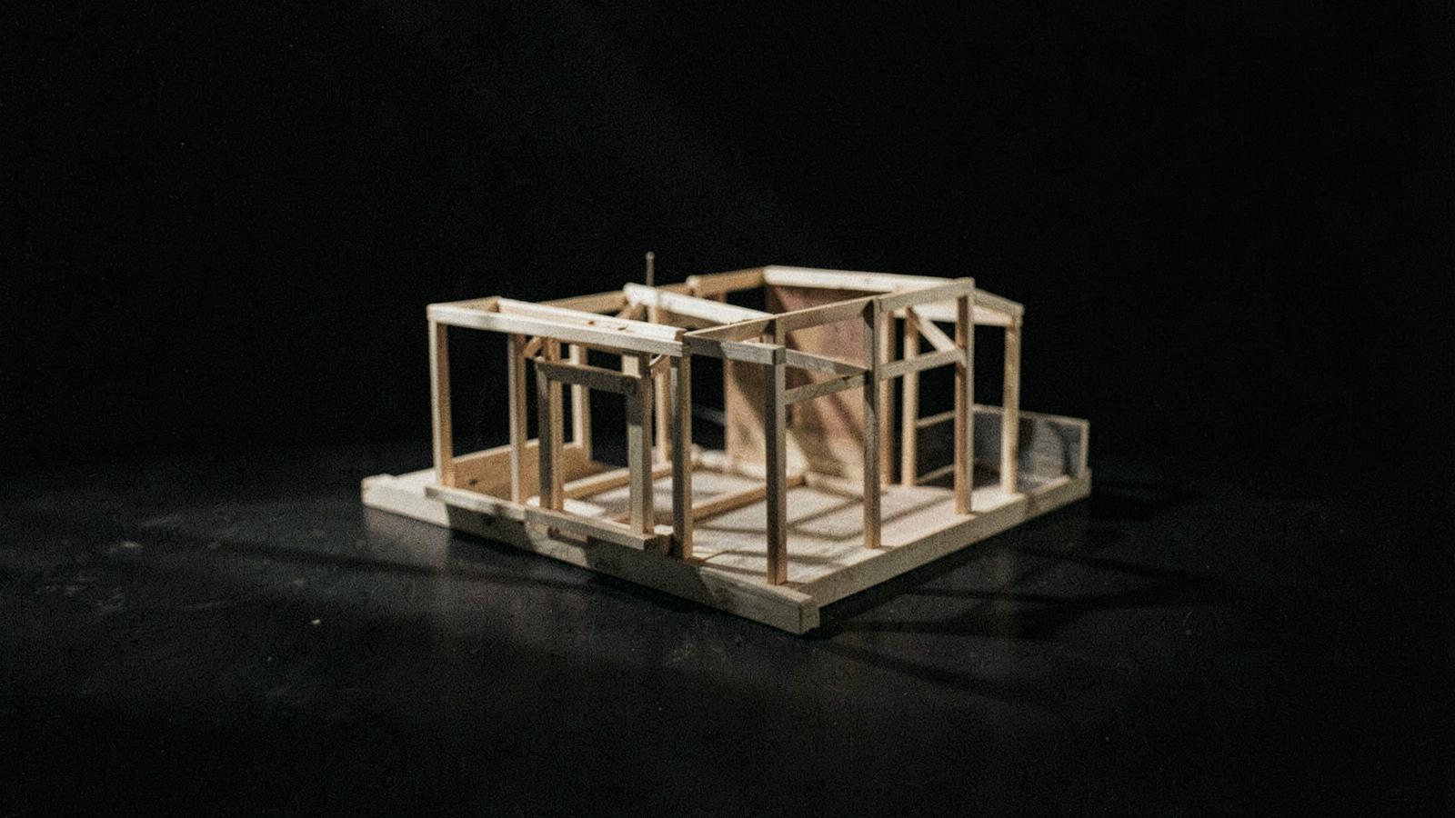 A small unfinished timber structure model in raking light
